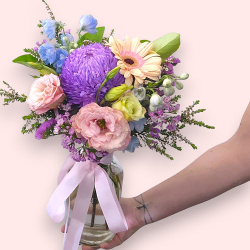 Pastel coloured flowers in a glass vase, designed by Bribie Island Flower Co
